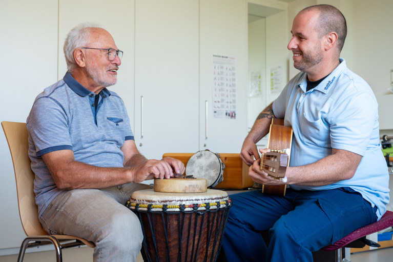 Therapeut und neurologische Rehabilitations-Patient während der Musiktherapie