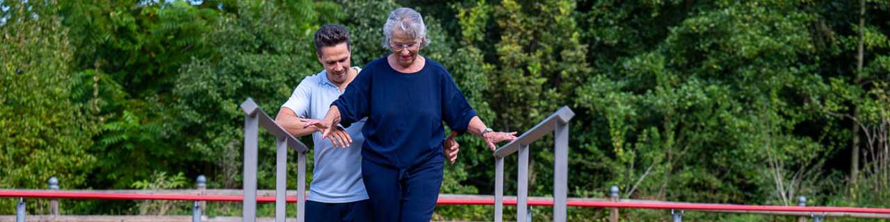 Therapist helping patient balance as part of neurologial rehabilitation